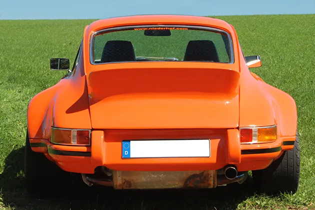 Blutoranger Porsche 964 Retro Classic Heckansicht mit prominentem Entenbürzel, Niederhof