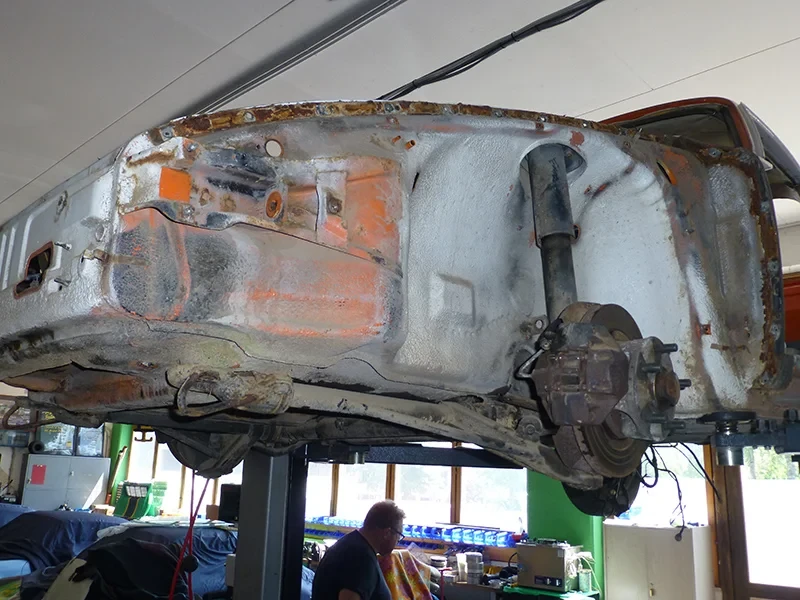 1975er Porsche 911 Coupe Unterboden auf Hebebühne, Anlieferzustand aus Japan mit Korrosionsspuren